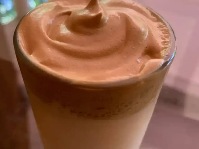 Café cremoso batido com açúcar e água quente: prato pronto