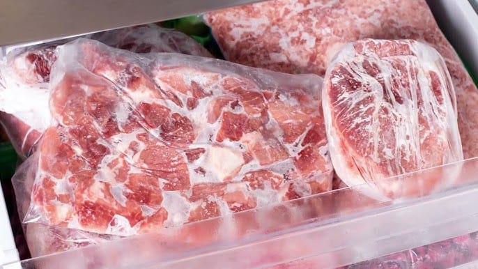 Pedaço de carne descongelando lentamente em uma tigela na geladeira para preservar a textura e o sabor.