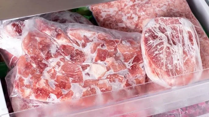 Pedaço de carne descongelando lentamente em uma tigela na geladeira para preservar a textura e o sabor.