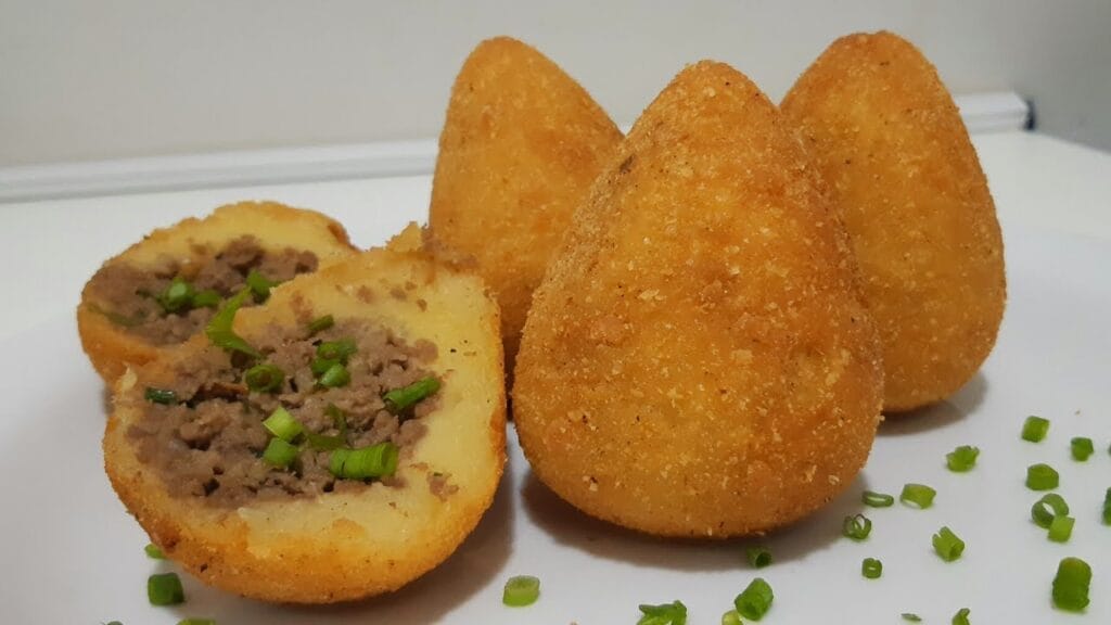 Coxinhas de mandioca fritas e douradas, prontas para servir.