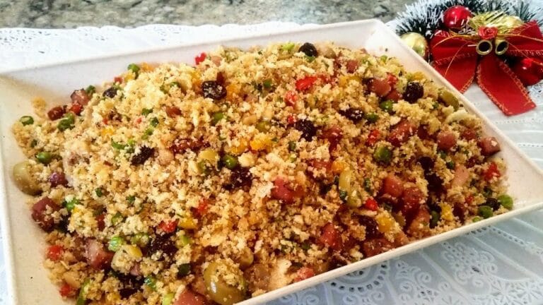 Farofa de Natal sendo preparada na frigideira com cebola dourada, bacon crocante, uvas-passas e castanhas-do-pará misturadas à farinha de mandioca.