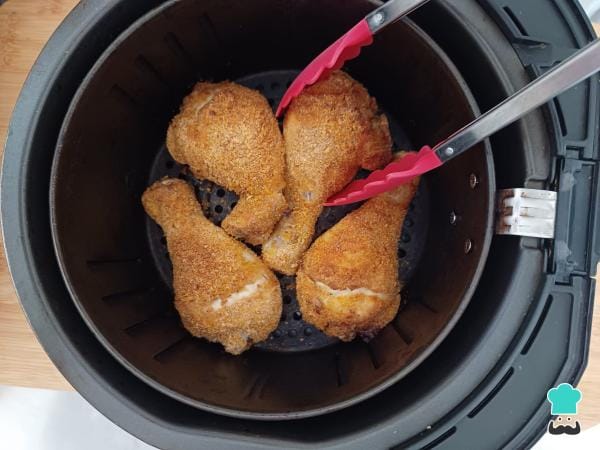 Peças de frango temperadas com ervas e especiarias, prontas para serem empanadas e cozidas na airfryer.