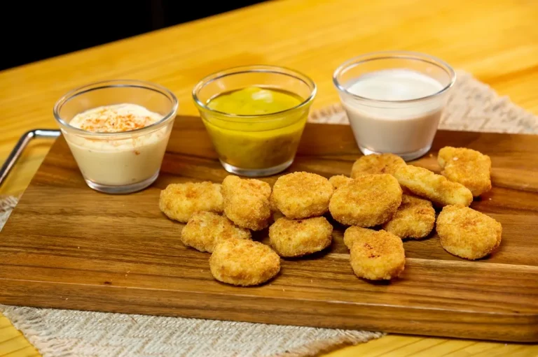 Nuggets de frango sendo preparados no micro-ondas com papel-toalha úmido para manter a umidade durante o cozimento.