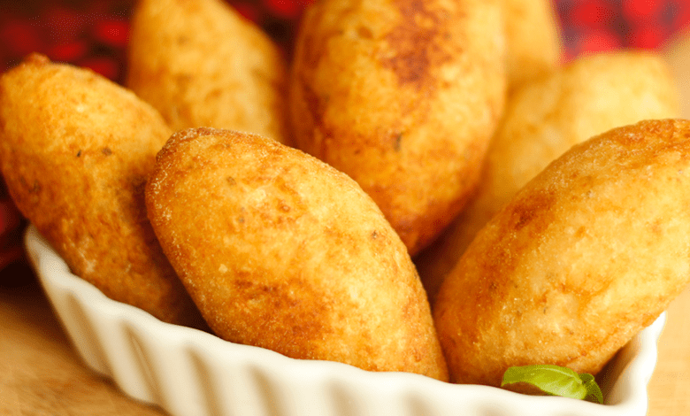 Cesta de bolinho de mandioca caseiro fritos, dourados e crocantes, prontos para serem degustados.