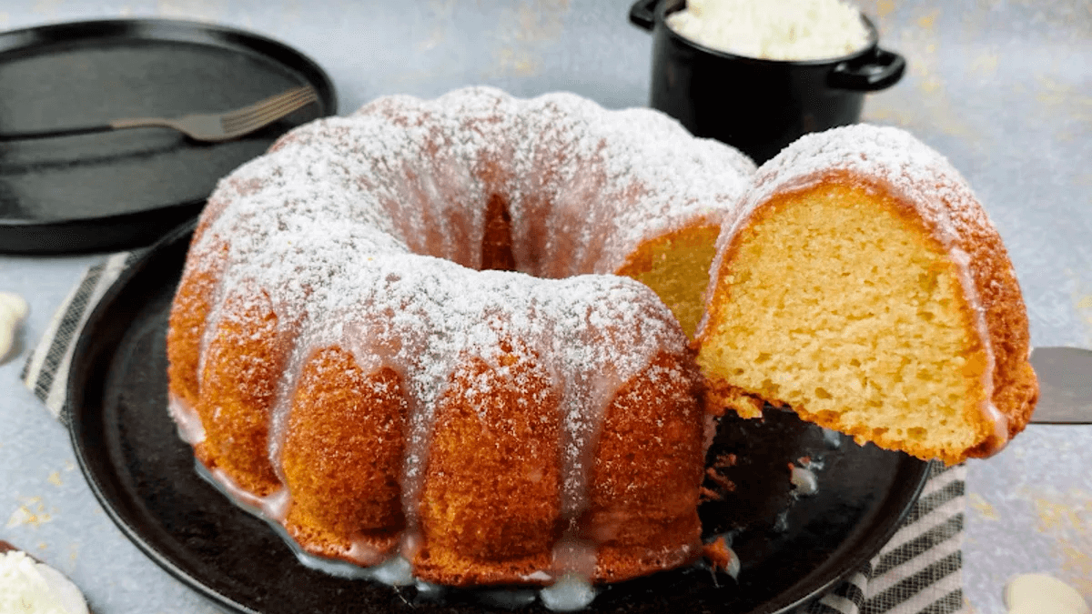 Bolo de leite quente fofinho e dourado, polvilhado com açúcar e canela