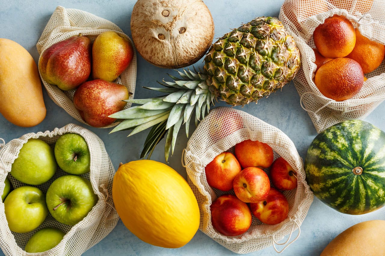 Uma mesa colorida com diversas opções de frutas frescas, representando as melhores escolhas para consumo após o almoço.