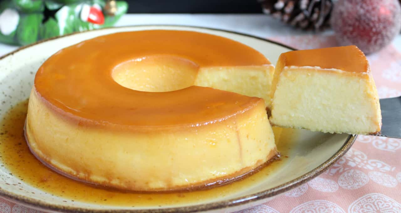 Calda de caramelo dourada e brilhante sendo despejada em uma forma de pudim.