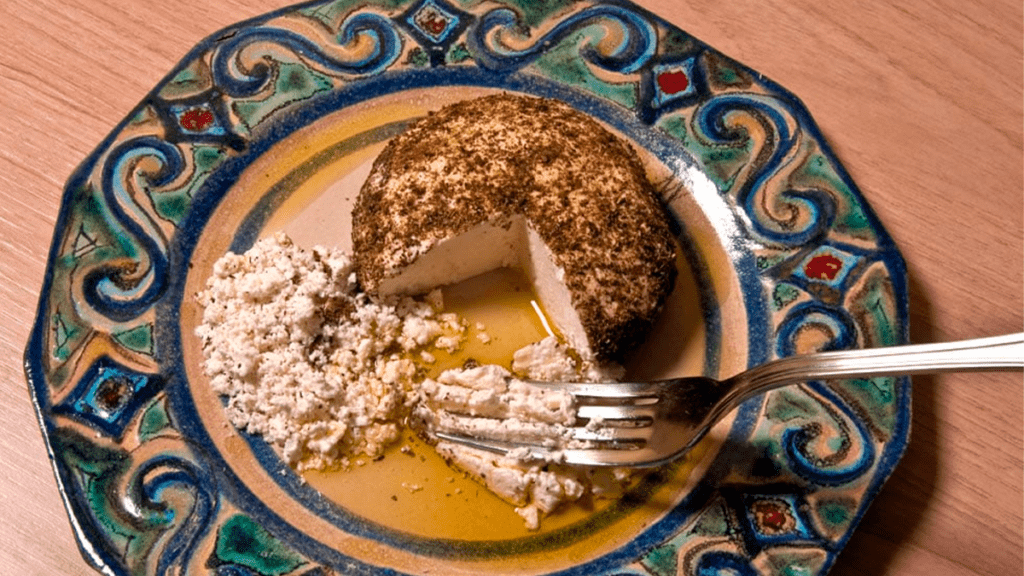 Bolinhas de queijo chancliche caseiro cobertas com zaatar, prontas para servir.