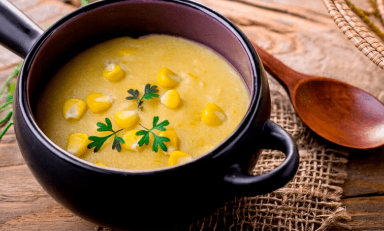 Angu de milho verde com queijo cremoso servido em uma tigela, com queijo derretido visível.