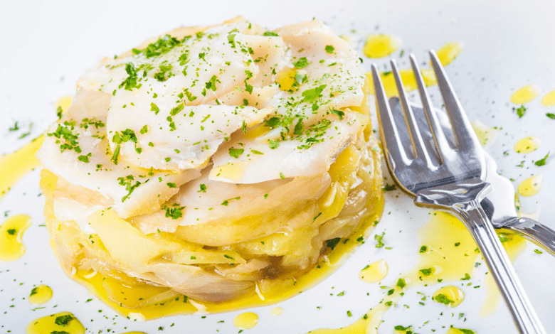 Bacalhau assado no forno, com batatas douradas e azeitonas, pronto para servir.
