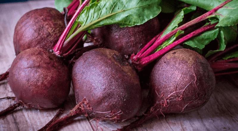 Beterrabas cozidas e inteiras, exibindo uma cor vermelha vibrante e intensa, representando o resultado ideal do cozimento e o tema principal do artigo.
