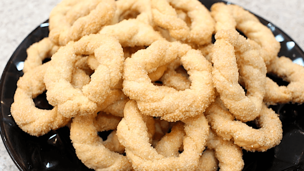 Biscoitos de cerveja dourados e crocantes, dispostos em uma compoteira rústica, prontos para serem degustados.