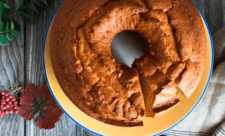 Um delicioso bolo de caramelo amanteigado recém-assado, com uma fatia sendo retirada, acompanhado de uma xícara fumegante de café.
