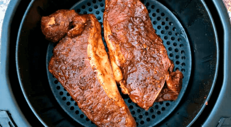 Bifes de contrafilé dourados e suculentos, recém-saídos da Airfryer, representando o resultado final da receita e a técnica ensinada no artigo.