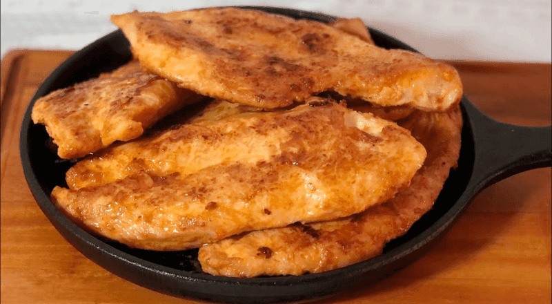 Pedaços de frango frito na frigideira, dourados e crocantes, representando o resultado final da receita e a técnica ensinada no artigo.