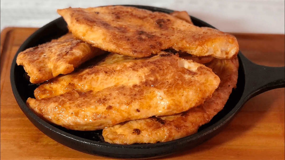 Pedaços de frango frito na frigideira, dourados e crocantes, representando o resultado final da receita e a técnica ensinada no artigo.