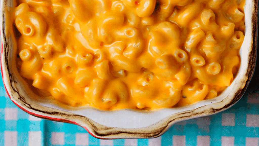 Macarrão com queijo cremoso gratinado, com queijo derretido e cobertura dourada.