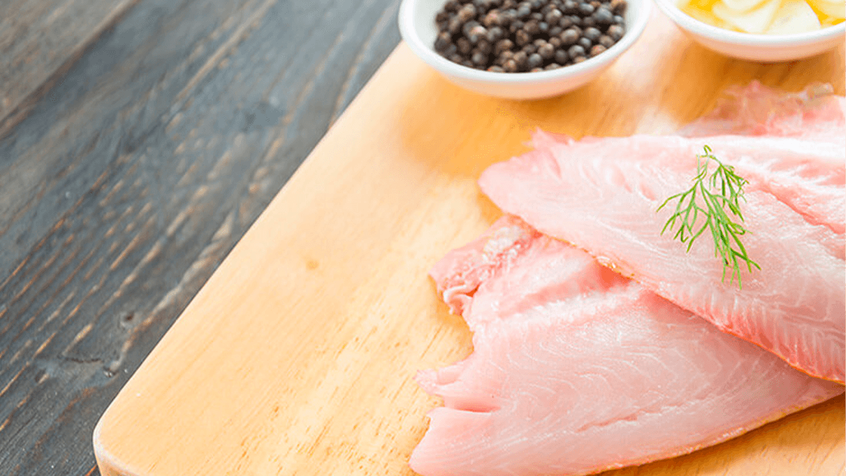 Close-up de um filé de merluza fresco, destacando a questão se merluza tem espinhos