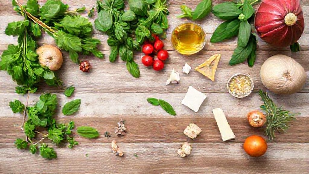 Ingredientes organizados em flat lay: ervas frescas, gengibre, limão, mel e água filtrada sobre bancada rústica.