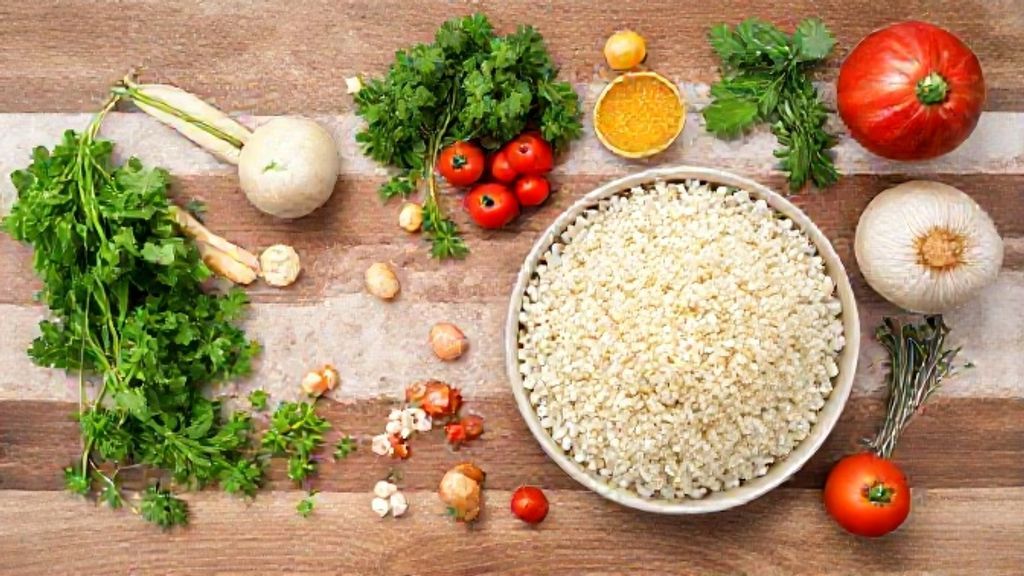 Ingredientes organizados em bancada de madeira: tapioca granulada, coco ralado, leite de coco e açúcar.