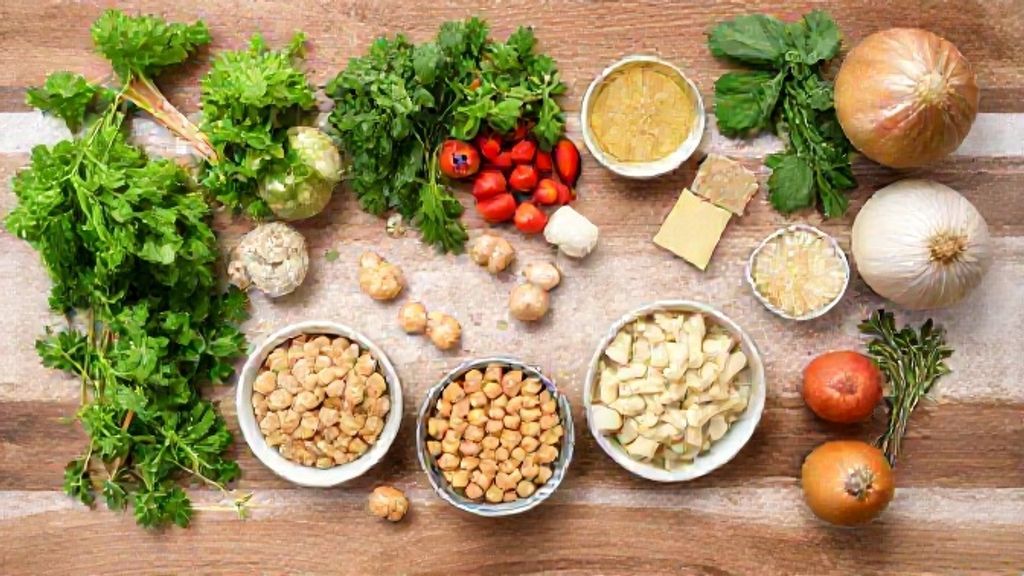 Vista de cima mostrando amendoim torrado, açúcar, farinha e sal arrumados em tigelinhas sobre bancada rústica