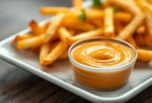 Molho Big Tasty caseiro cremoso servido em um potinho, com textura lisa e cor alaranjada, ao lado de batatas fritas douradas