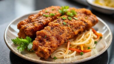 Costela de tambaqui frita dourada, servida com limão e farofa, aparência crocante e suculenta.