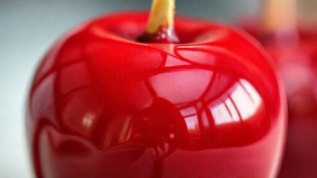 Close-up mostrando o brilho intenso e textura firme da calda de maçã do amor pronta.