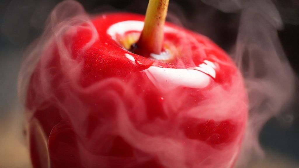 Close-up na textura lisa e brilhante da maçã do amor, destacando o tom vermelho intenso