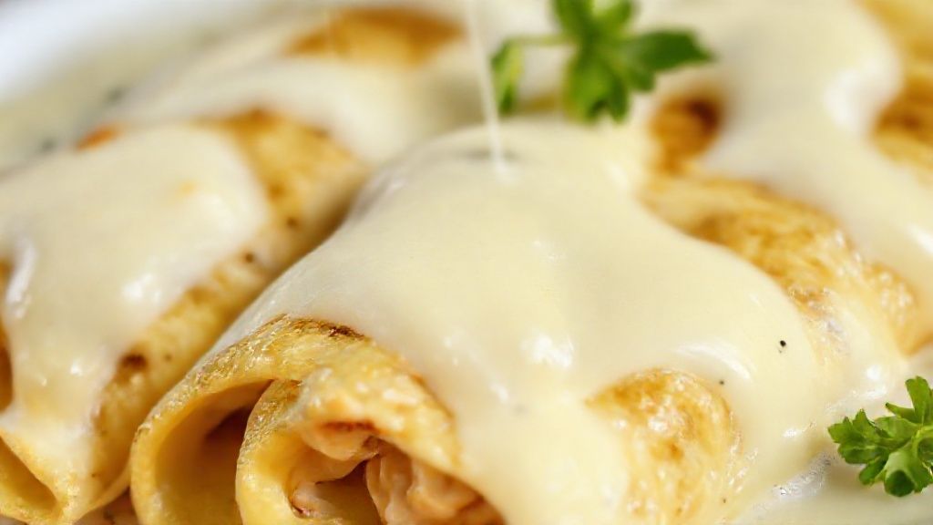 Close-up do corte da panqueca mostrando o recheio cremoso de frango e o queijo gratinado