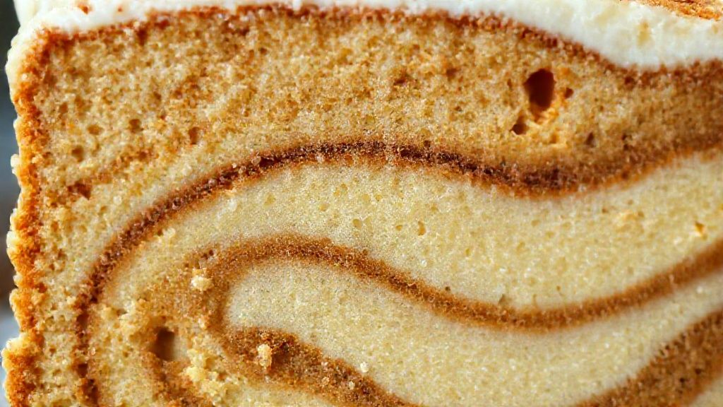 Close-up da fatia do bolo mesclado mostrando a textura fofa e as camadas de doce de leite
