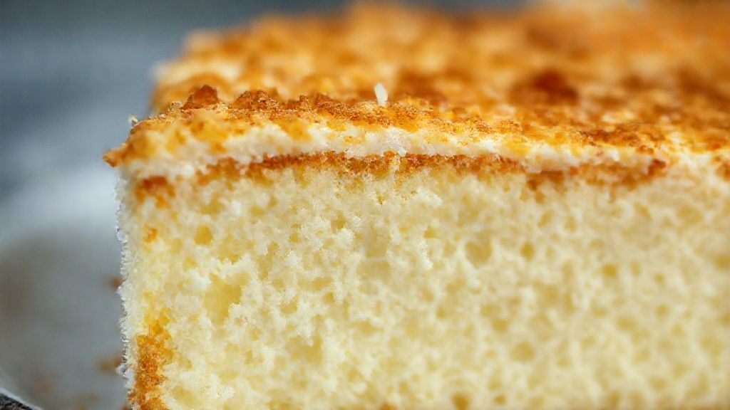 Close-up do bombocado de mandioca com coco mostrando textura cremosa e superfície dourada