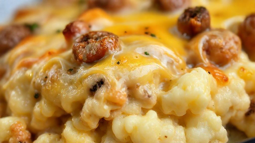 Close-up do escondidinho pronto, destacando o queijo derretido e o interior cremoso do purê.