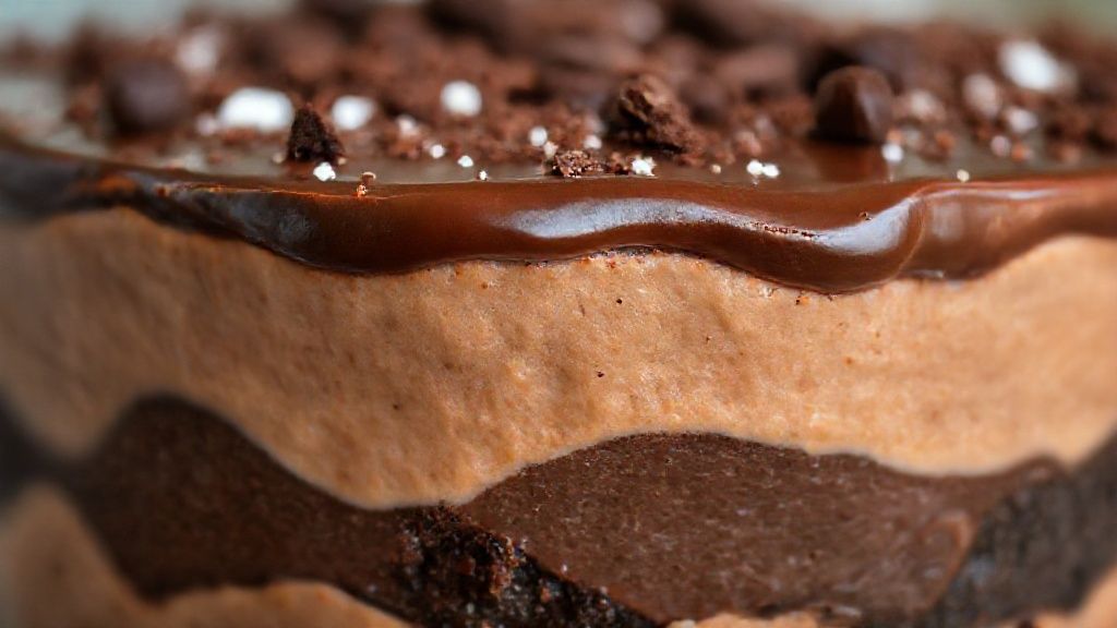 Close-up do pavê cremoso gelado pronto, mostrando as camadas e a textura da ganache brilhante