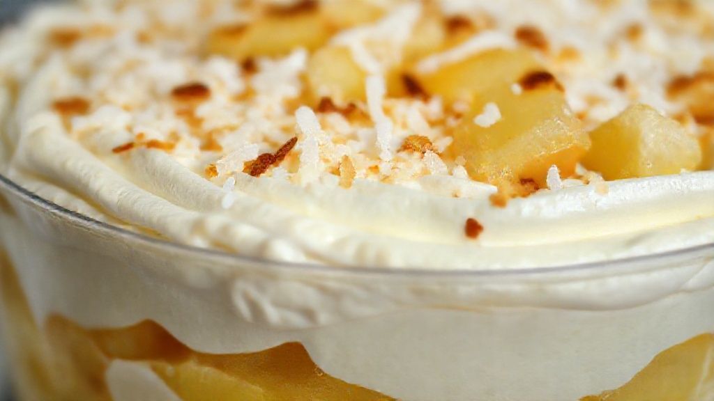 Close-up do pavê pronto mostrando as camadas cremosas e a textura do chantilly com amêndoas.