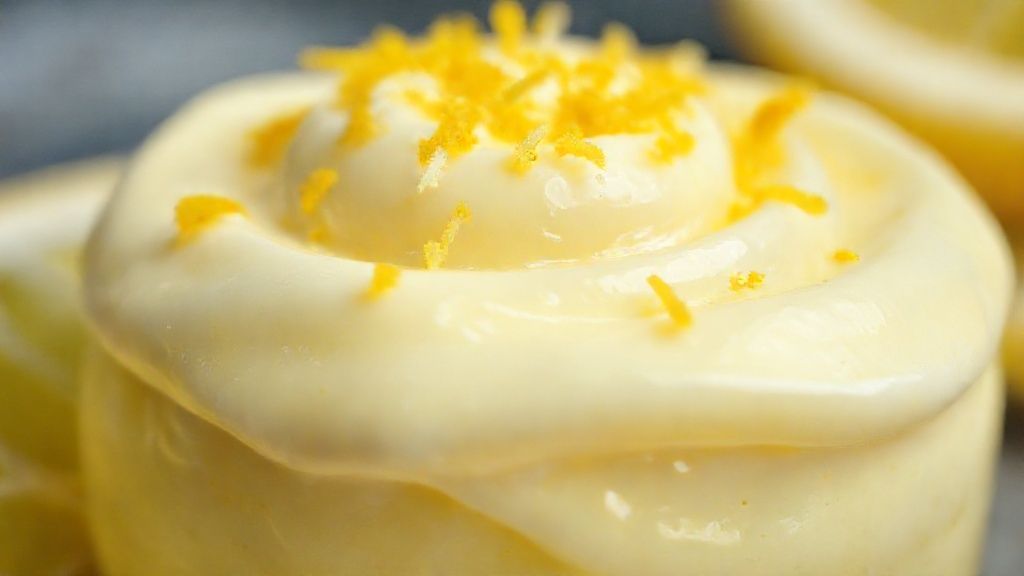 Close-up do pudim com textura cremosa e raspas de limão sobre o topo