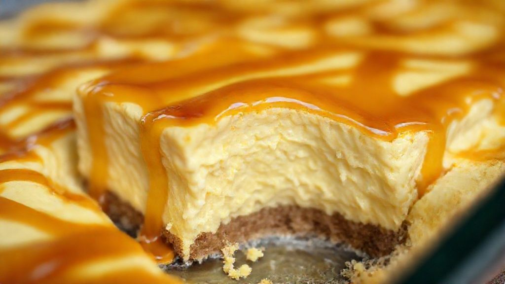 Close-up mostrando a textura cremosa e o brilho da calda caramelizada sobre o pudim.