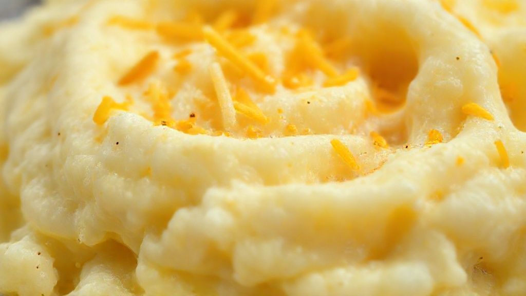 Close-up do purê finalizado, destacando a cremosidade e o brilho do queijo derretido