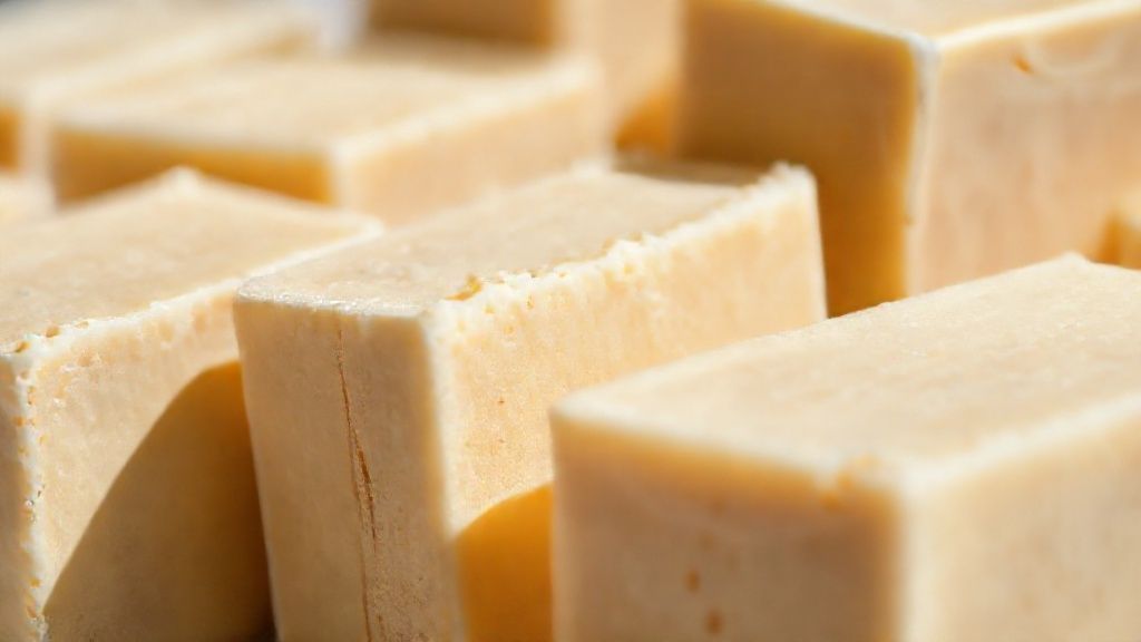 Close-up das barras de sabão mostrando textura firme e cor suave, em foco macro