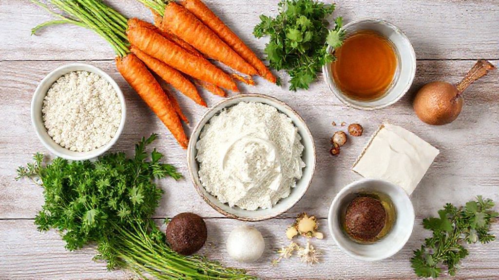 Visão de cima mostrando cenouras, ovos, farinha, açúcar e chocolate dispostos em bancada de cozinha