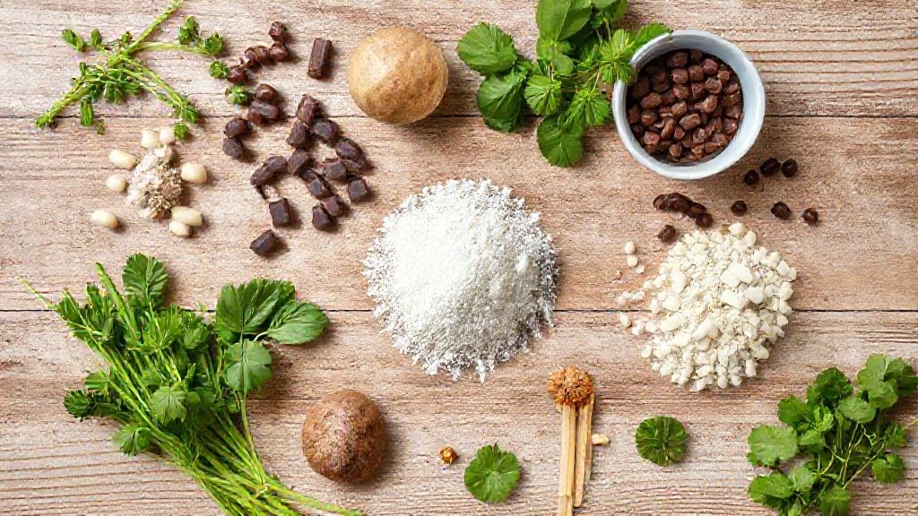 Visão de cima com banana, ovo, aveia, maisena e chocolate 70% organizados em uma bancada de madeira