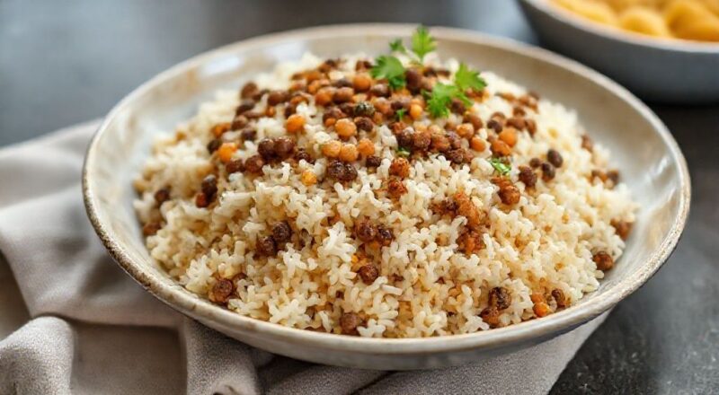 Prato de arroz com lentilha macio, com cebolas douradas sobre o topo, servido em travessa rusticamente elegante