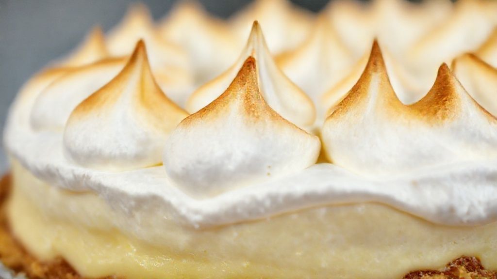 Close-up do prato pronto, destacando o merengue dourado e o creme de limão cremoso