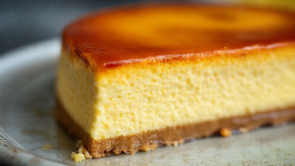 Close-up do bolo pudim cortado, mostrando a camada macia de bolo e a parte interna cremosa