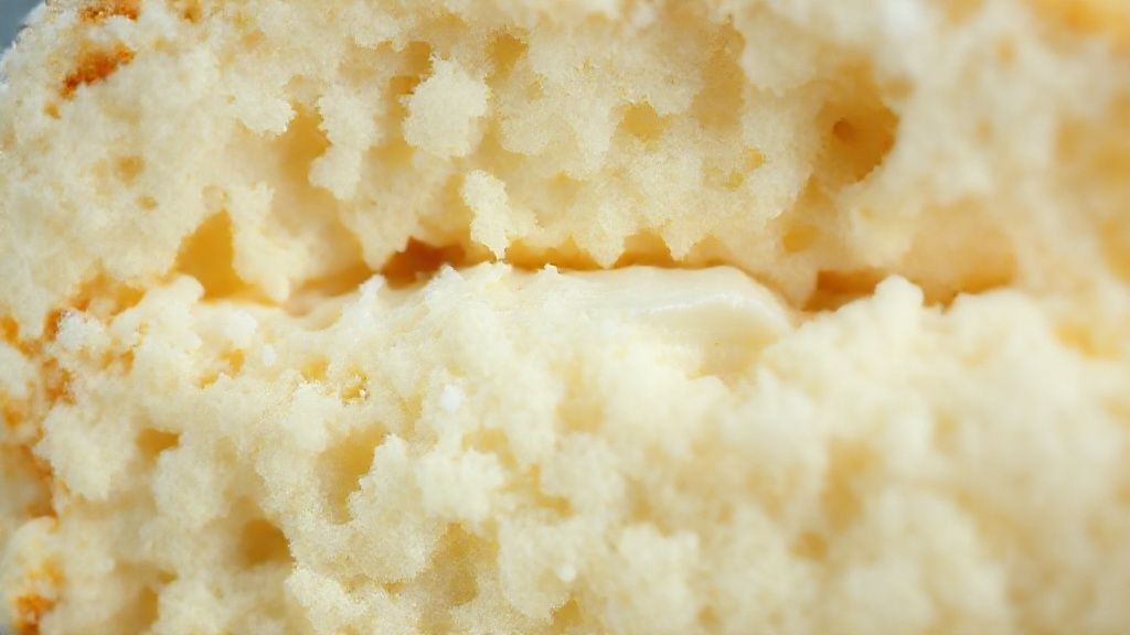 Close-up da fatia do bolo sonho mostrando o recheio cremoso e a textura leve da massa