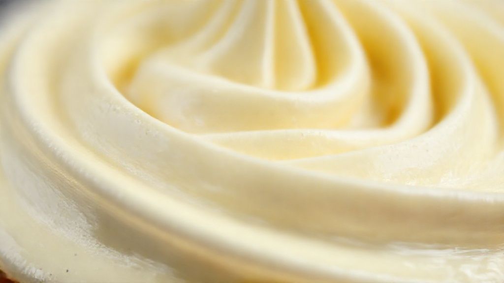 Close-up mostrando a textura cremosa e firme do chantininho pronto, com picos suaves e aparência sedosa