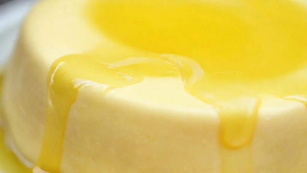 Close-up do pudim de limão sem forno cortado, mostrando textura cremosa e calda brilhante