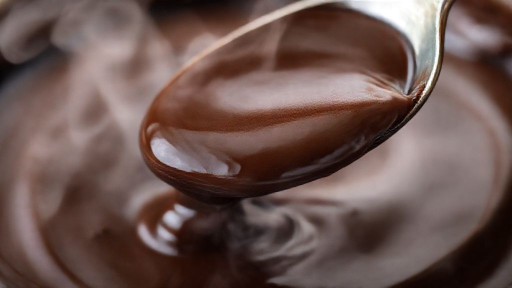 Close-up do recheio de chocolate pronto, destacando brilho e textura cremosa