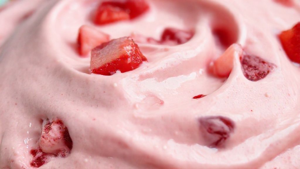 Close-up do mousse de morango pronto, destacando sua textura cremosa e os pedaços de fruta
