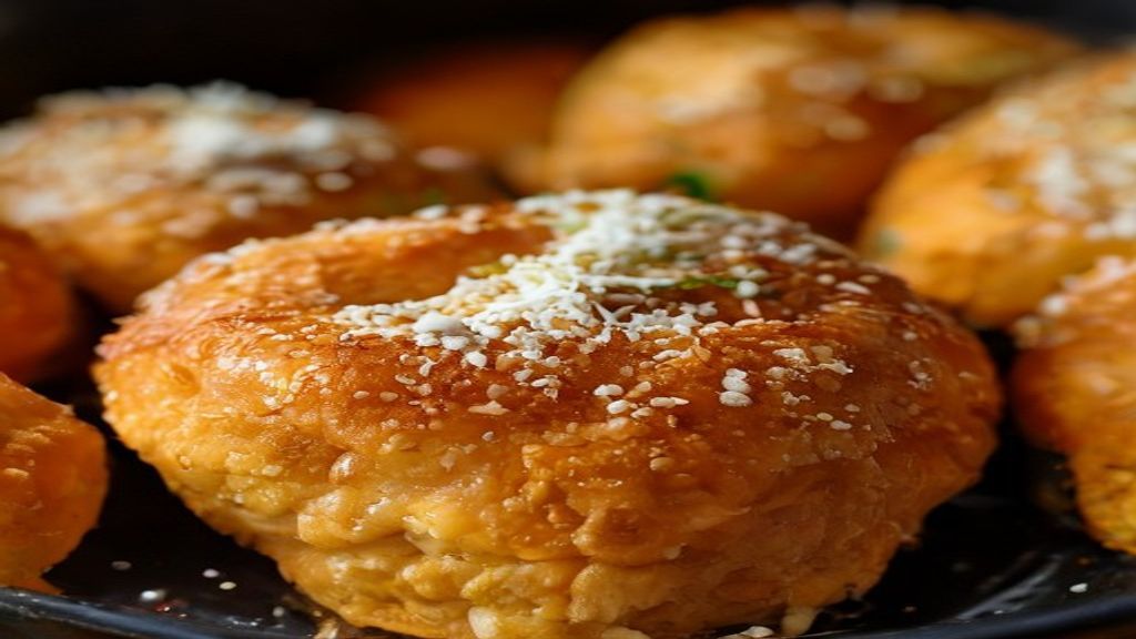 Close-up de um pão de queijo aberto mostrando o interior elástico e textura aerada